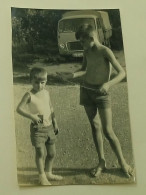 Two Boys On The Street Behind A Truck - Anonyme Personen