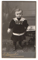Fotografie Franz Heinrich, Torgau, Portrait Niedliches Kleinkind In Hübscher Kleidung Mit Buch An Hocker Gelehnt  - Anonyme Personen