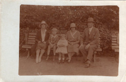 Carte Photo D'une Famille élégante Posant Assise Sur Un Banc Dans Un Jardin Public Vers 1920 - Anonymous Persons
