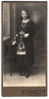 Fotografie W. Fischer, Berlin, Niederbarnimstr. 24, Junge Dame Frida Im Schwarzen Kleid Mit Perlenkette Und Blumenstra  - Anonyme Personen