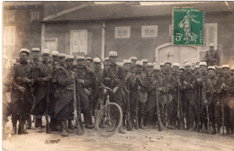 Carte Photo D'une Compagnie De Soldats Francais En Tenue De Combats Et Avec Leurs Fusil Et Un Vélo Dans Un Village - Guerra, Militares