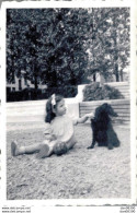 PHOTO DE 9 X 6 CMS FILLETTE AU NOEUD DANS LES CHEVEUS ASSISE PAR TERRE AVEC SON CHIEN NOIR - Anonyme Personen