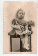 Cpa Photo " Petite Fille Assise Sur Une Table Avec Une Poupée Alsacienne Dans Les Bras ( Photo Tampon Vanackère Lille ) - Speelgoed & Spelen