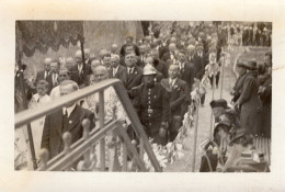 Carte Photo D'hommes Dont Un Officier Des Pompier Défilent Pendant Une Procession Religieuse Dans Une Ville - Anonieme Personen