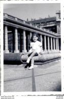 PHOTO DE 9 X 6 CMS UNE FILLETTE EN ROBE ASSISE DEVANT UN BATIMENT A COLONNES - Personas Anónimos