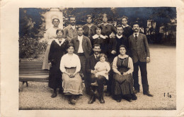 Carte Photo D'une Famille élégante Posant Dans Un Jardin Public Dans Une Ville - Personnes Anonymes