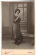 Fotografie Strauss & Co., Wien, Portrait Frau Hella Müller Im Blümchenkleid Mit Schürze Vor Einer Studiokulisse, 19  - Anonyme Personen