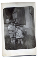 Carte Photo De Deux Petit Enfant Posant Devant Leurs Maison - Personnes Anonymes