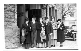 Carte Photo D'une Famille élégante Posant Devant Leurs Immeuble Avec Une Voiture A L'arrière - Anonymous Persons