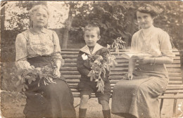 Carte Photo De Deux Femmes élégante Avec Un Petit Garcon Assis Sur Un Banc Dans Leurs Jardin Vers 1910 - Anonymous Persons