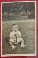 PH - Ph Original - Garçon Surpris Assis Dans Un Parc, Jouant Avec Sa Petite Girafe 1950 - Anonieme Personen