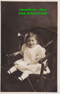 R422720 A Little Girl In A White Dress Is Sitting On A Chair. Postcard - Welt