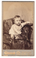 Fotografie Dupont, Bruxelles, 109 Rue Neuve, Portrait Süsses Kleinkind Im Hemdchen Auf Einem Sofa Sitzend  - Anonieme Personen