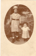 Carte Photo D'une Jeune Fille élégante Avec Une Petite Fille Posant Dans Leurs Jardin Vers 1920 - Personnes Anonymes