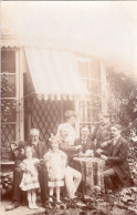 Carte Photo D'une Famille élégante Jouent Au Carte A Table Devant Leurs Maison Vers 1905 - Personas Anónimos