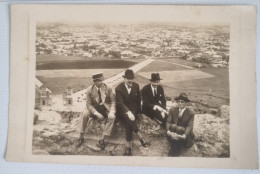 PH Originale - Un Grand Nombre D'hommes Assis Au Sommet D'une Montagne Rocheuse Avec La Ville Au Loin - Personas Anónimos