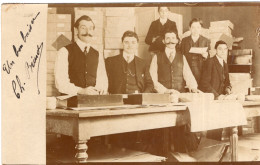 Carte Photo D'hommes Et De Jeune Garcon Travaillant Derrière Leurs  Bureau Dans Une Usine En 1908 - Anonymous Persons
