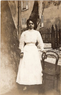 Carte Photo D'une Jeune Fille élégante Posant Dans La Cour De Sa Maison En 1905 - Personnes Anonymes