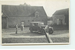 Carte Photo - Automobile - Un Couple Près D'une Voiture Dans Une Cour De Ferme - Voitures De Tourisme