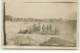 Carte Photo à Localiser - Groupe De Personnes Ayant Fait Des Bancs Sur Une Plage, Au Fond Des Cabines De Plages - A Identifier