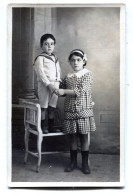 Carte Photo D'une Jeune Fille élégante Avec Un Petit Garcon élégant Dans Un Studio Photo Vers 1930 - Anonymous Persons