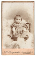 Fotografie M. Krzywinski, Grossröhrsdorf, Grossmannstr., Portrait Niedliches Mädchen Im Karierten Kleid Auf Fell Sit  - Anonyme Personen