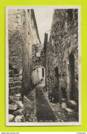 06 EZE N°5 Une Rue Dans Les Années 40 Femme Assise Sur Le Pas De Porte VOIR DOS - Eze