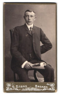 Fotografie G. Brems, Bremen, Landwehrstr. 40, Portrait Junger Mann Elegant Im Anzug Mit Zeitschrift In Der Hand  - Anonyme Personen