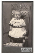 Fotografie H. Leske, Spandau, Schönwalderstr. 2, Baby In Einem Trachtenähnlichen Kleid Auf Einem Stuhl Stehend  - Anonyme Personen