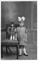Carte Photo D'une Petite Fille élégante Avec Sa Poupée Posant Dans Un Studio Photo A Ste-Croix-aux-Mine En 1926 - Anonymous Persons