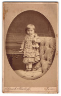 Fotografie Bernh. Bischoff, Jena, Niedliches Kleinkind Im Karrierten Kleid Mit Puppe Im Arm  - Anonymous Persons