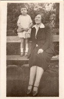 Carte Photo D'une Femme élégante Avec Sa Petite Fille Posant Sur Un Banc Dans Un Jardin Public - Personas Anónimos