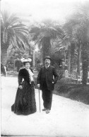 Carte Photo D'une Femme élégante Avec Un Homme Posant Dans Un Jardin Public En 1906 - Anonyme Personen