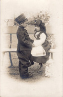 Carte Photo D'une Petite Fille élégante Avec Un Petit Garcon Déguisé Posant Dans Un Jardin - Anonyme Personen