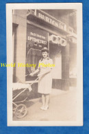 Photo Ancienne Snapshot - Portrait Jeune Femme & Pousette Devant Magasin BURTON Optometrist Opticien Lunettes Fille Robe - America