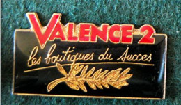PIN'S ÉPOXY " VALENCE 2 LES BOUTIQUES DU SUCCÈS " _DP136 - Trademarks