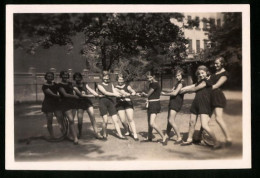 Fotografie Mädchen In Sportbekleidung Beim Tauziehen Auf Dem Schulhof  - Sporten