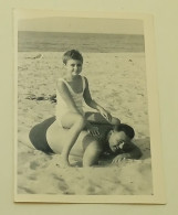 A Little Girl Sits On A Man's Back On The Beach - Personnes Anonymes