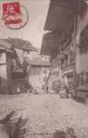 Gruyères - Rue De L'Eglise, Animée, Boulangerie, épicerie, Mercerie, Tourniquet De Cartes Postales. Carte-photo. Censure - Gruyères