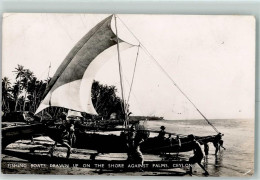 52221441 - Fishing Boats Drwan Up On The Shore Against Palms - Sri Lanka (Ceylon)