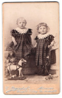 Fotografie C. Pagendorf, Hannover, Georgstrasse 17, Portrait Zwei Kleine Mädchen Im Karierten Kleid Mit Spielzeugpferd  - Anonyme Personen