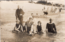 Carte Photo D'une Famille En Maillot De Bain Assise Sur Une Plage Animé Vers 1920 - Personnes Anonymes