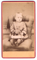 Fotografie A.H. Johannson, Erfurt, Domstr. 6, Kleinkind Auf Sessel Mit Spielzeugpferd  - Anonyme Personen