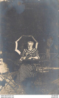 CARTE PHOTO NON IDENTIFIEE REPRESENTANT UNE FEMME AGEE ASSISE A UNE TABLE DE JARDIN TENANT UNE OMBRELLE - A Identifier