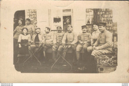 CARTE PHOTO NON IDENTIFIEE REPRESENTANT UN GROUPE DE SOLDATS ET UNE FEMME ASSIS A LA TERRASSE D'UN CAFE - To Identify