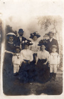 Carte Photo D'une Famille élégante Posant Dans Un Décor De Campagne Dans Un Studio Photo Vers 1910 - Personnes Anonymes