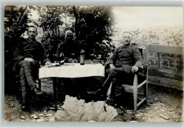 39872141 - Drei Offiziere In Uniform Mit Einer Flasche Wein Am Gartentisch - War 1914-18