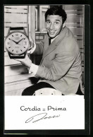 AK Cordia-Prima, Mann Zeigt Eine übergrosse Uhr In Die Kamera  - Autres & Non Classés