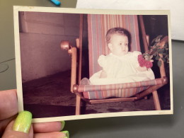 Photo Snapshot Photo Couleur 1960' Bébé, Assis Dans Une Chaise Longue Fleurs à La Main Rose, Petite Fille En Blanc - Personnes Anonymes