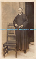 R178503 A Clergyman Standing Next To A Chair - Wereld